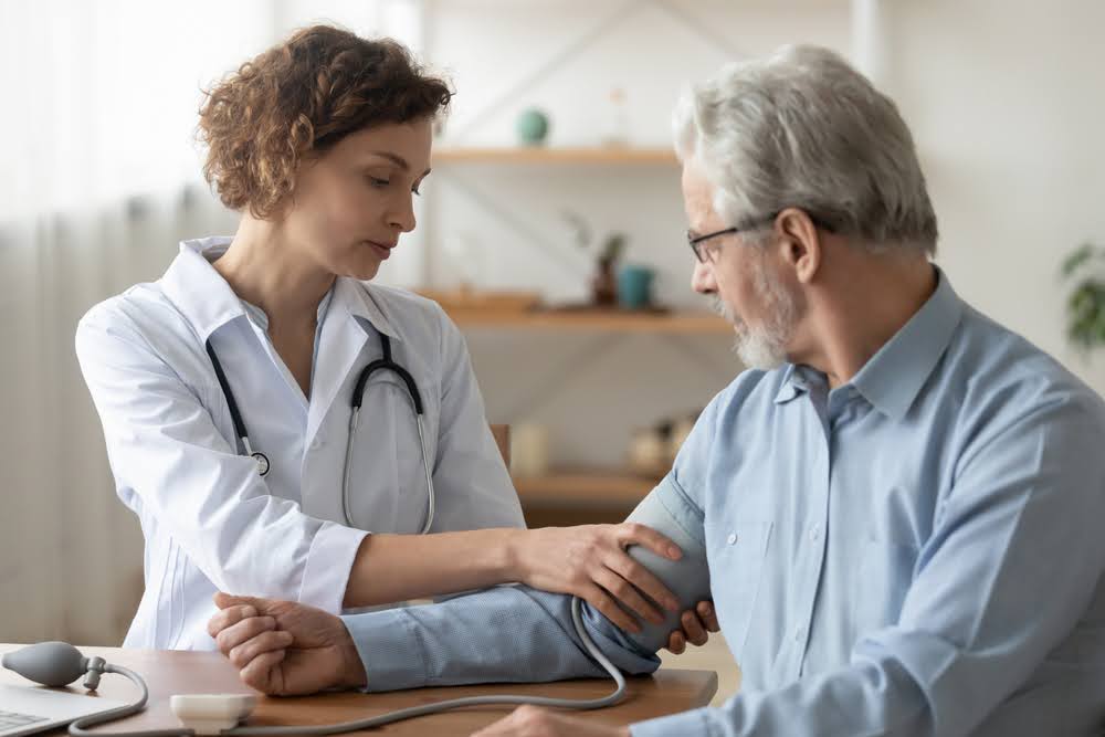 Female professional doctor examining elderly old male patient