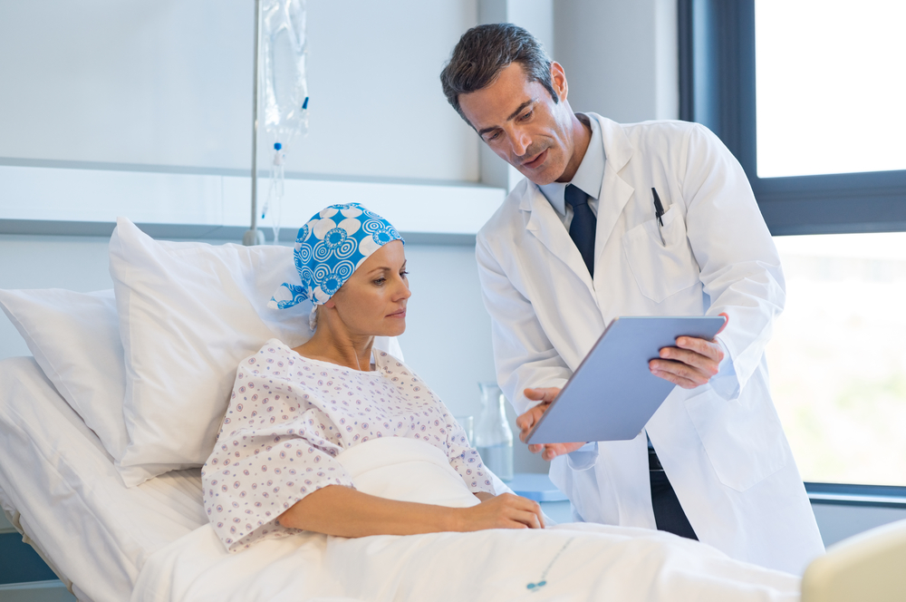 A doctor showing a cancer patient test results on a tablet.