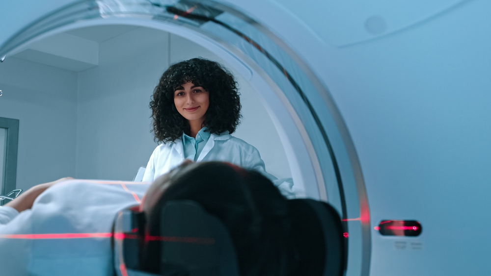 A doctor monitoring a patient in an imaging machine.