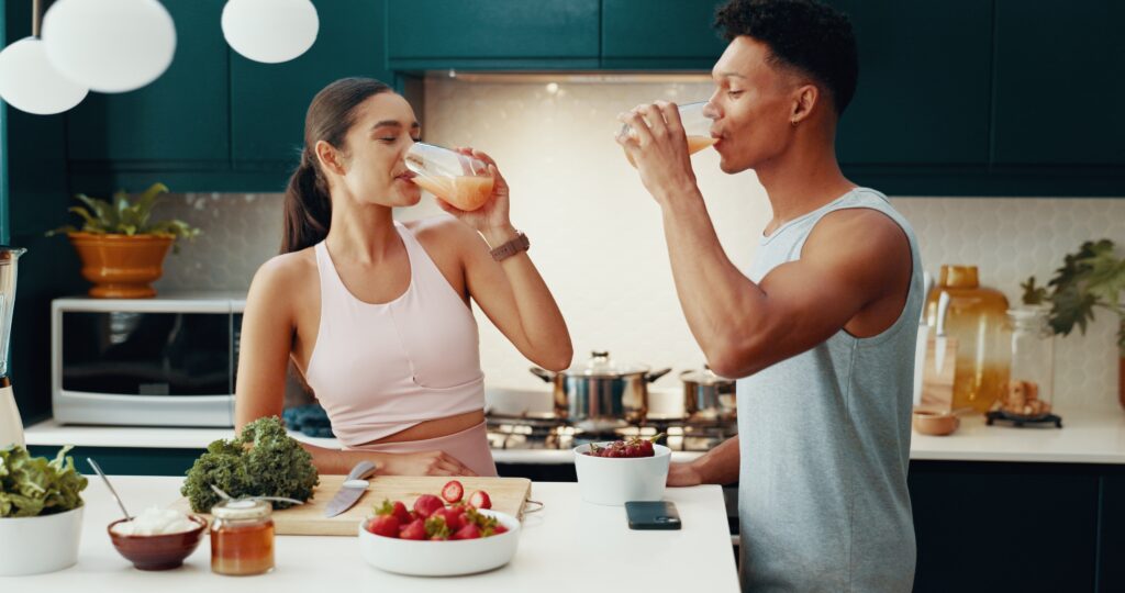 Couple eating whole foods together in kitchen.