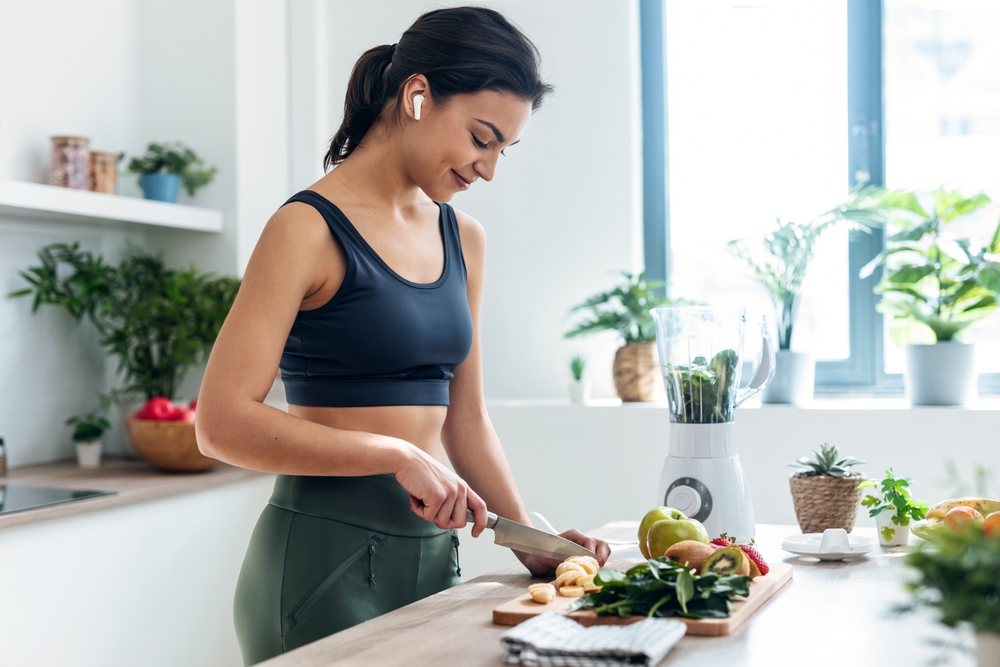 slim woman preparing healthy food after successful bariatric surgery