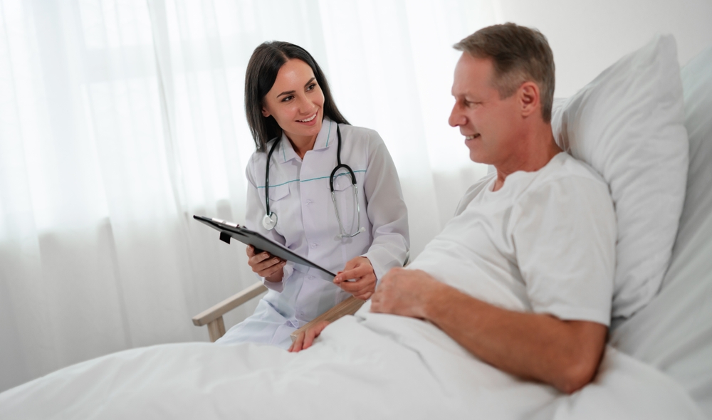 A doctor talking to a patient in a hospital bed.