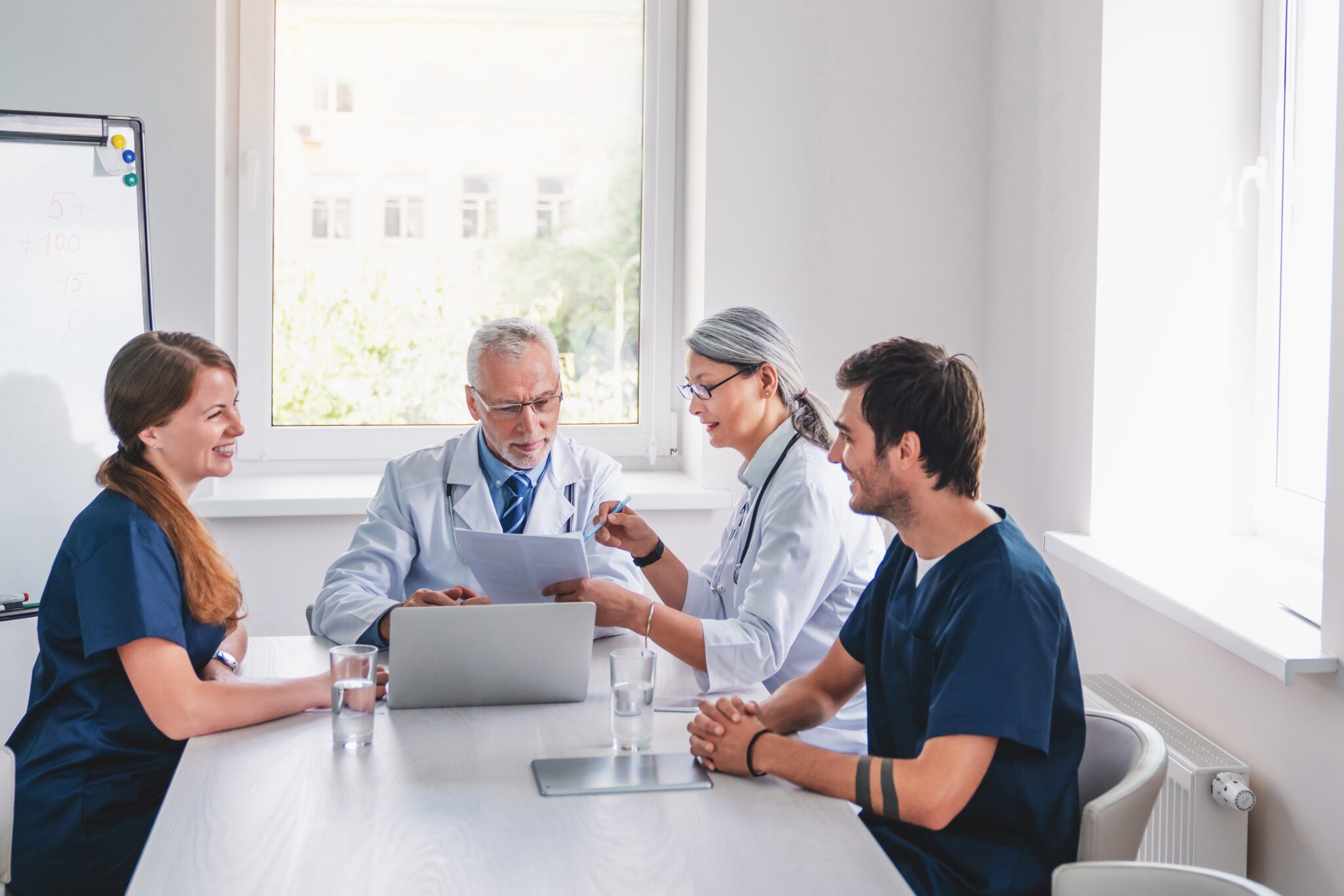 Multidisciplinary medical team reviewing patient records at tumor board meeting