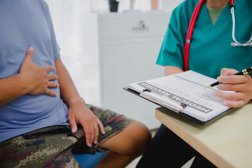 A man talking to his doctor about stomach pain.