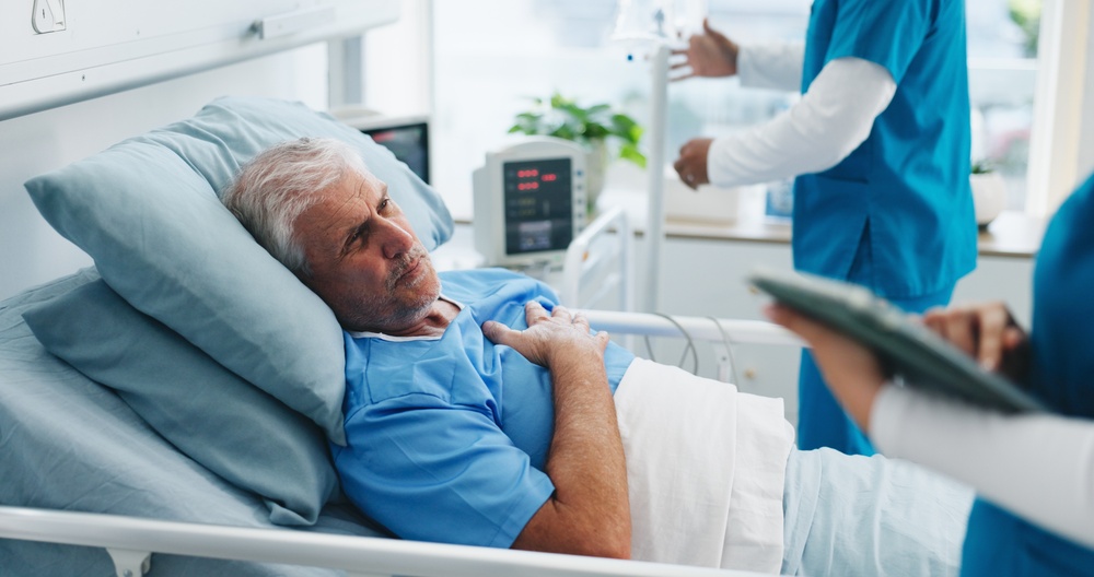 Surgeon caring for a patient in a hospital bed after carotid artery surgery